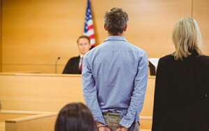 Man in handcuffs standing before a judge