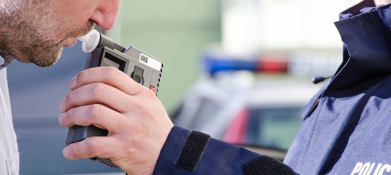 Person getting a breathalyzer test from a police officer