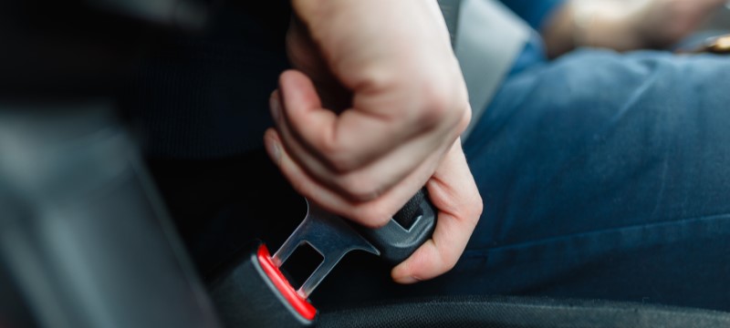 Person buckling their seat belt in Florida