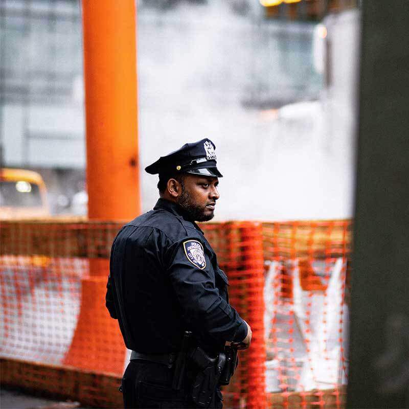 Police officer stands in patrol of a construction site.