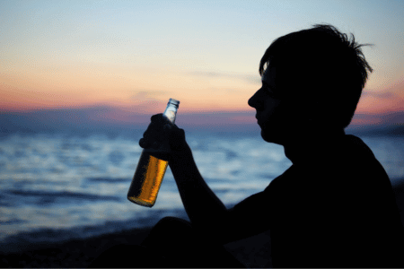 Person drinking a beer on the beach