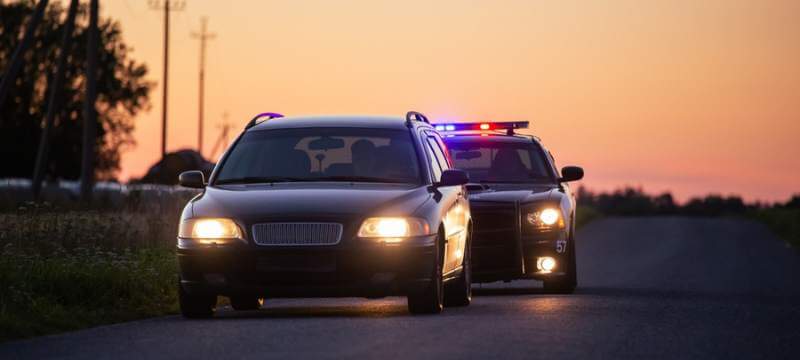 Cop car with lights on to pull over a driver without a license