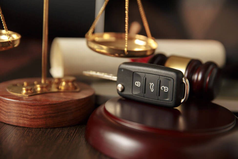 Car keys resting next to a gavel and scales