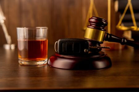 DUI legal penalties with alcohol and a court gavel.
